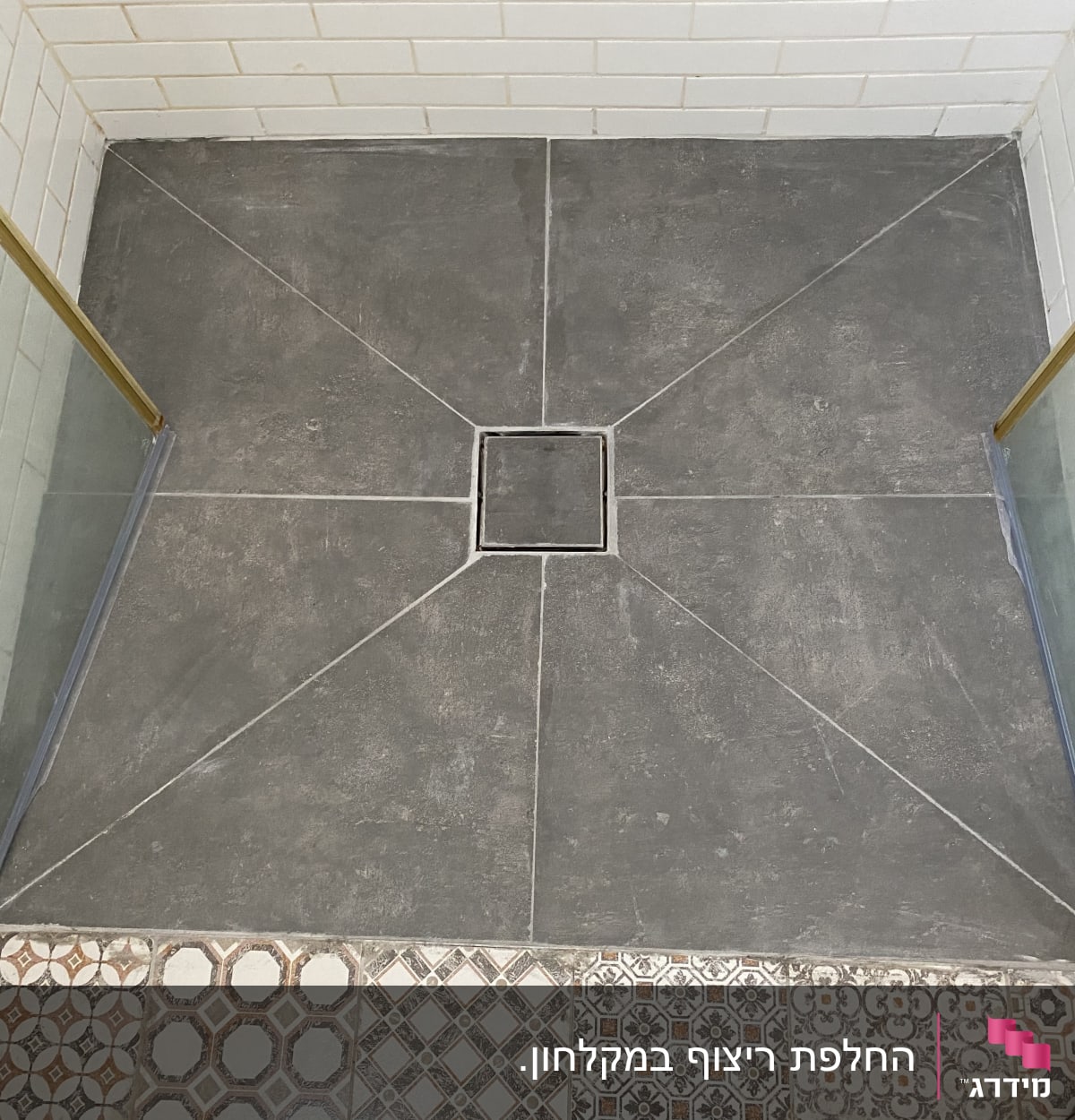 ריצוף חדש במקלחת עם אריחים אפורים וניקוז מרכזי